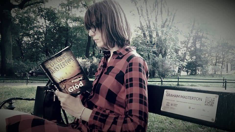 Polish fan reading Famine on Krakow park bench